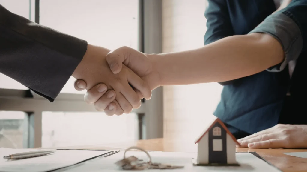 poignee de main entre deux personnes avant un deal immobillier